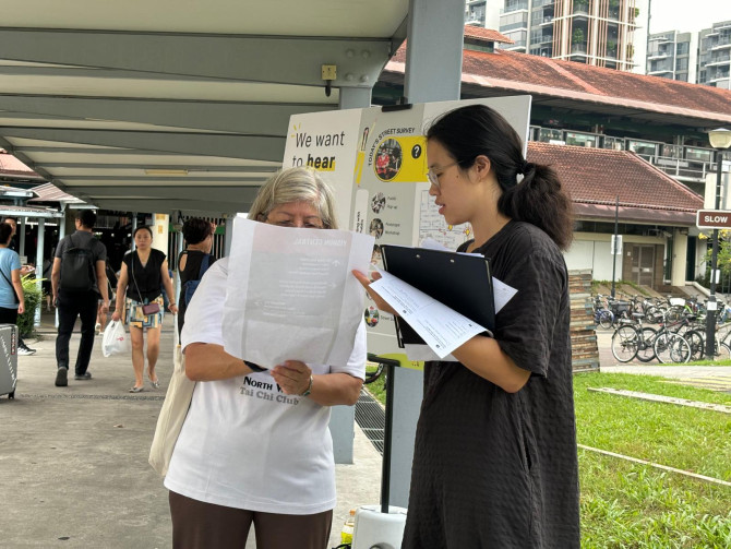 Desai Wang interviews a resident of Singapore about metro station signs.