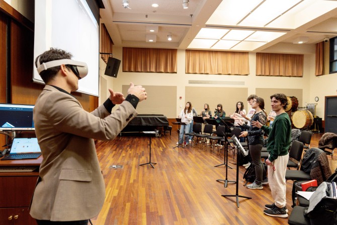 A professor models using a VR headset to conduct an ensemble.