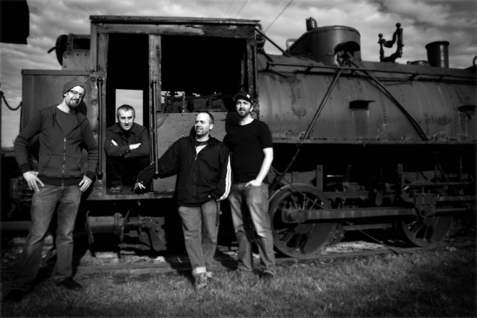 Four people standing by a train