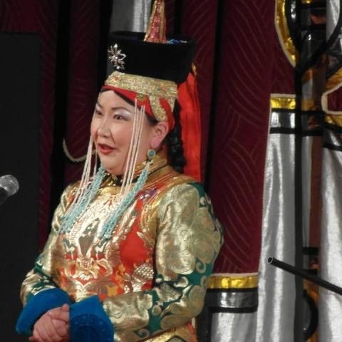 Person singing in brightly colored traditional costume of Mongolia