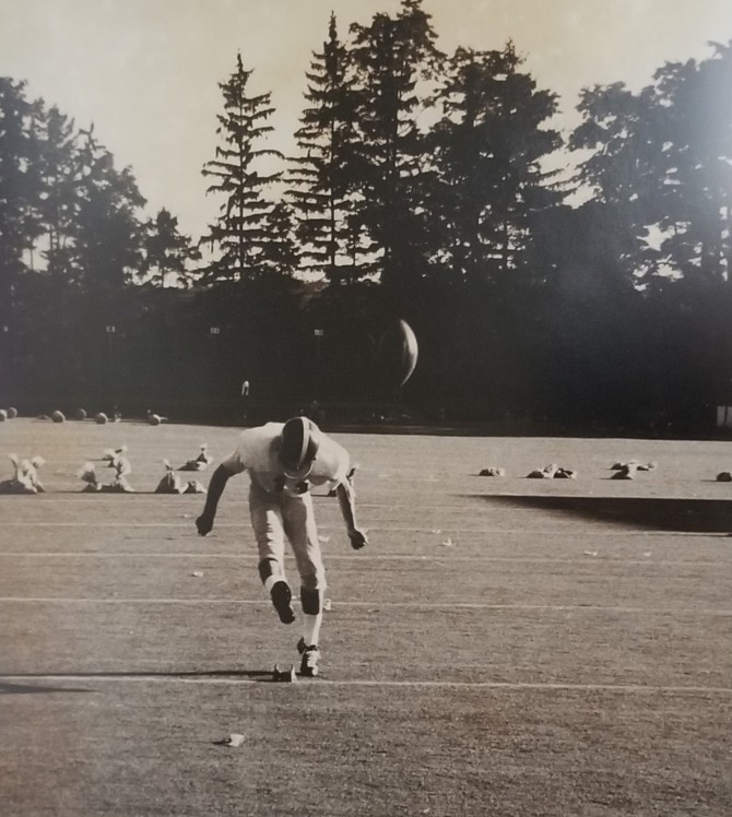 black and white photo of H. Jay Spiegel ’74 kicking a football
