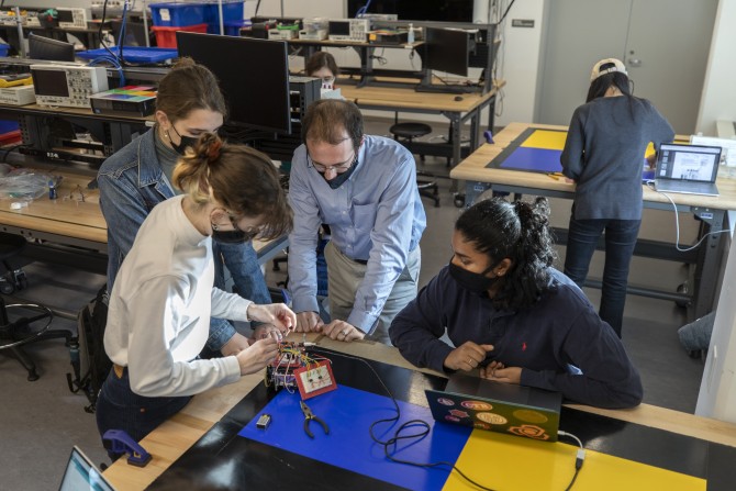 Instructor Benjamin Finio works with Molly Drumm, Emily Harmon, and Sunaya Reddy on their robot project