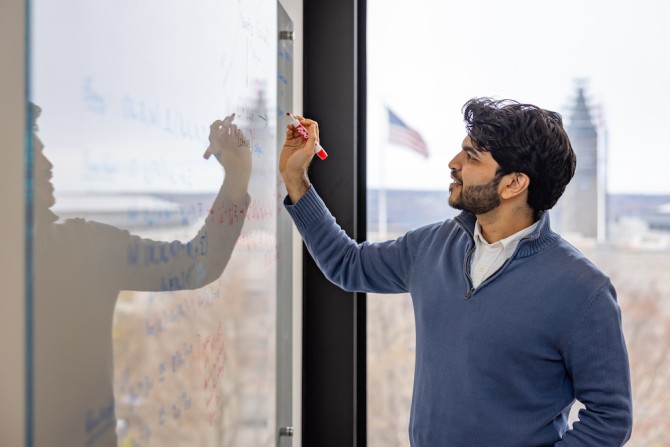 Person writing on a dry-erase board