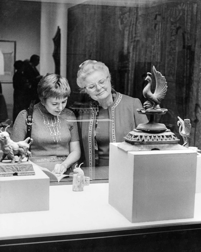 Visitors at the Indianapolis Museum of Art view “Oval Cista with Thruhai Finial (Toilet Box with Bird Top),”