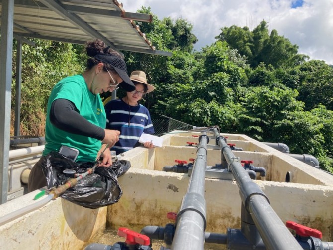 two women work on an outdoor water system