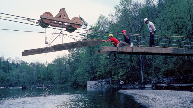 Students from the Class of 1983 built a trolley to shuttle sections of the bridge across the creek.