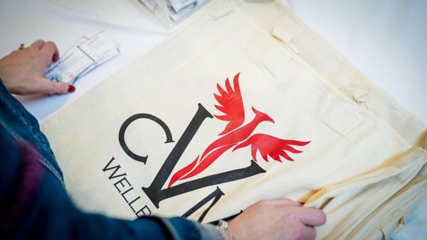 A tote bag with the CVM well-being firebird logo