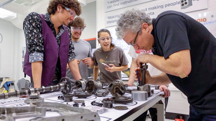 Students learn about mechanical engineering by disassembling an engine in the Learning Studios, spearheaded by Brian Kirby, the Meinig Family Professor of Engineering (right).
