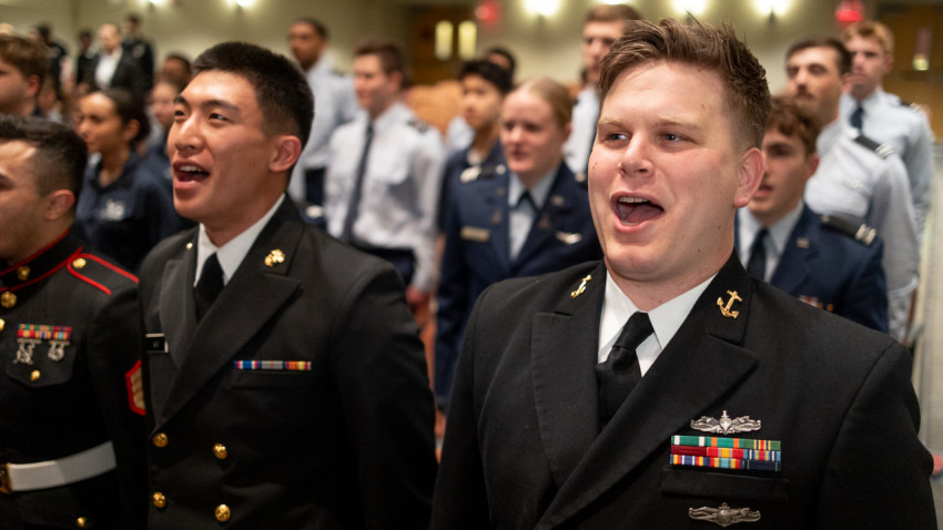 Sidney Anop ’26, right, shown during an ROTC awards ceremony in April, started his Navy career as an enlisted information systems technician. Now an ensign, the ILR School graduate is the first member of Cornell Navy ROTC to commission through the Seaman to Admiral-21 program.