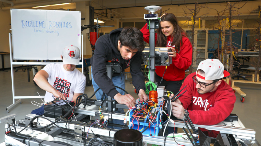 Andrew James ’26 (from left), Neil Morrison ’28, Natalia Kurz ’29 and Michael Neiss ’27 work on a prototype of their weed-killing robot ahead of The Farm Robotics Challenge, which they won on May 21.