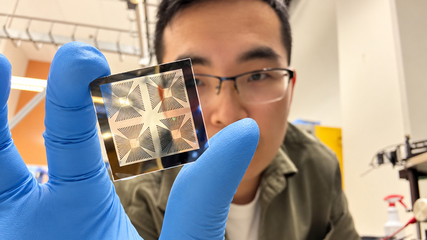 Cornell physics researcher Zhiyuan Zhang holds a chip containing an array of the devices he developed to create microscopic bubbles on demand, when and where they are needed.