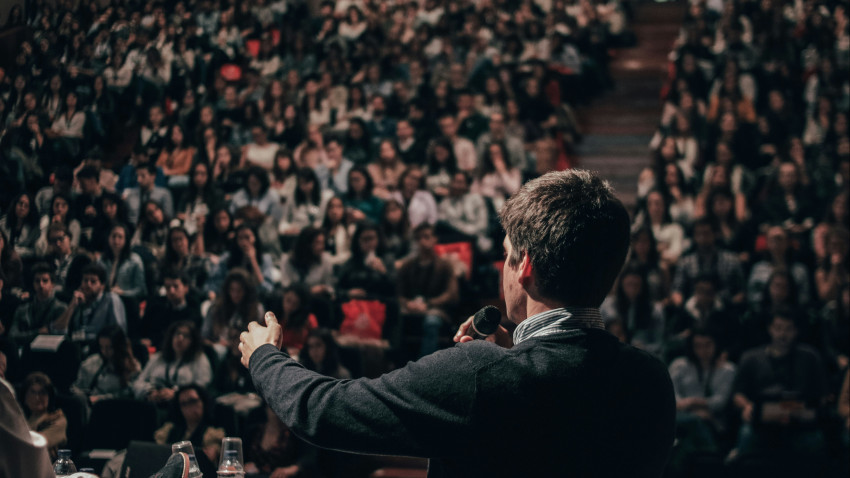speaker talking to a crowd of people