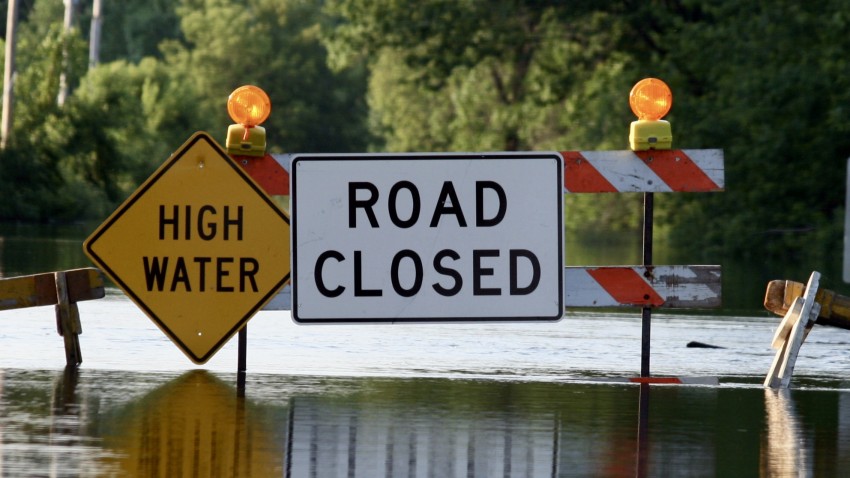 flooded street signs say high water road closed