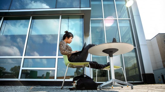 A student works outside the Human Ecology Building.