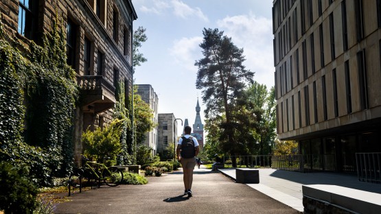 A student walks through campus between Olin Library and Stimson Hall.