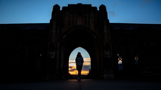 Students pass through the War Memorial in the early evening light.