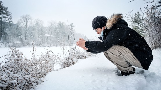 A student stops to take a winter photo at Beebe Lake.