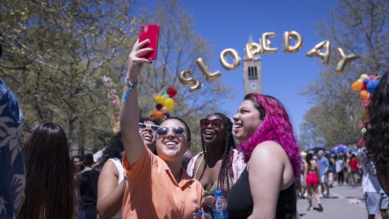 Students taking a selfie in front of Slope Day banner on Ho Plaza. 