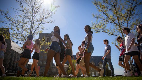 Students smile at the camera while walking to Slope Day. 