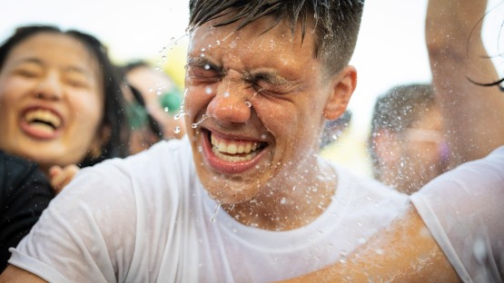 A student shakes off water from his face. 
