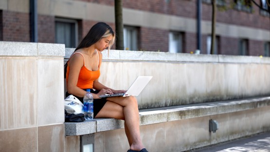 A student works outside the Physical Science Building. 