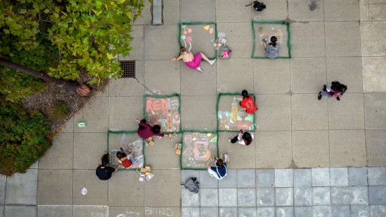 Aerial view of students drawing in chalk on Ho Plaza