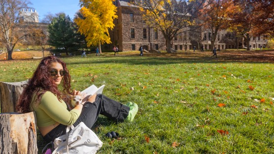 A student works with her study buddy by Sibley Hall on the Arts Quad.