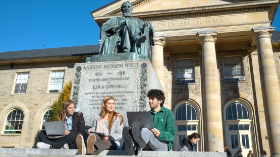 Students study in front of the A.D. White statue on the Arts Quad.