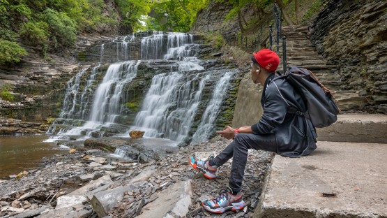 An engineering student enjoys a quiet moment in Cascadilla Gorge.