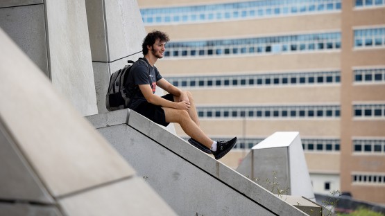 A student takes in the view outside Gates Hall.