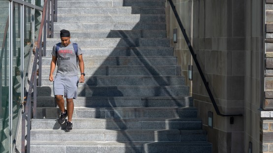 A student descends the stairs outside the Physical Science Building.