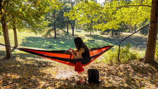 A student works on a crochet project in the comfort of a hammock atop Libe Slope.