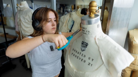 A student designs and creates clothes in the Human Ecology Building.