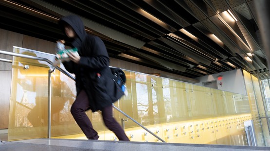 A student climbs the stairs of Upson Hall.
