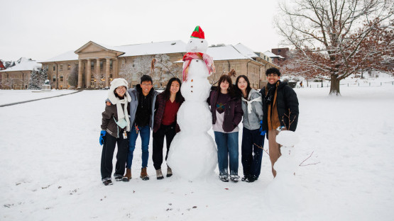 Students build a large snowman on the Arts Quad.