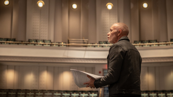 Film composer Michael Abels listens to a rehearsal with Cornell Wind Symphony in Bailey Hall.