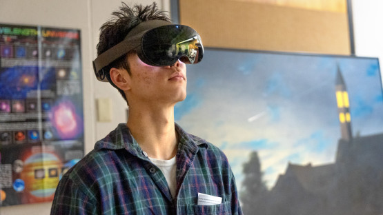 A student from New Visions looks through a VR headset at the Spacecraft Planetary Image Facility