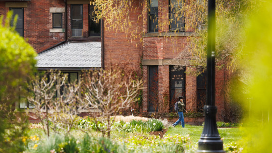 Person walks past the brick walls of the A.D. White House