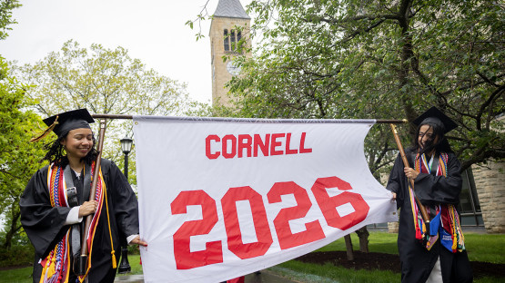 Two  students carrying the Cornell 2026 banner. 