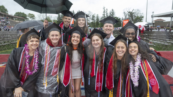 Graduates pose for a picture while leaving the field. 