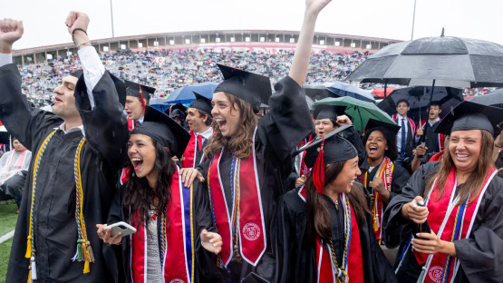 Graduates celebrating on the field. 