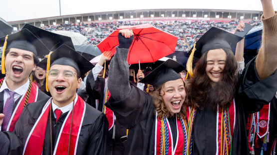 Graduates cheering on the field. 