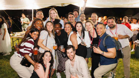Reunion 2026 attendees pose under a tent at night