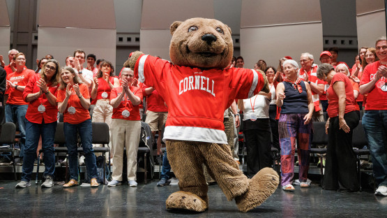 Bear mascot in front of reunion attendees