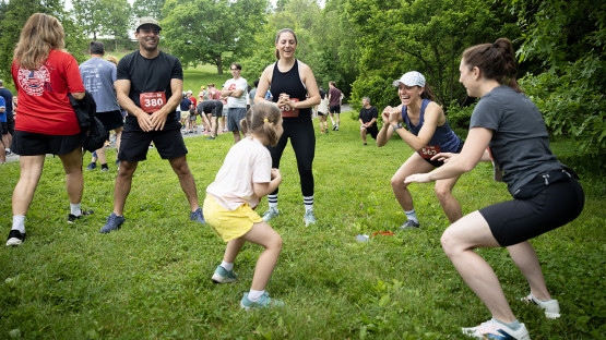 Reunion attendees wearing running numbers do squats