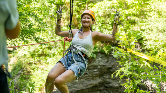 A reunion attendee dangles from a climbing harness