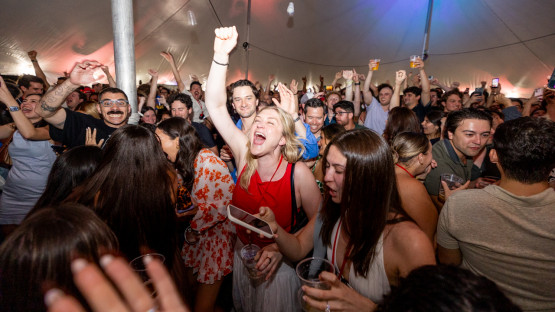 Reunion attendees dance under a tent