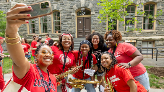 A group of reunion attendees with musical instruments pose for a selfie