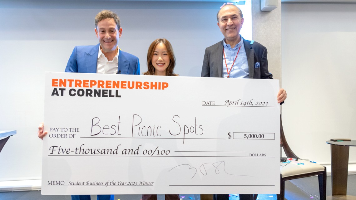 Cornell Entrepreneur of the Year Barry Beck ’90, left, and Sam Sotoodeh MBA ’87, right, present the Student Business of the Year award to Karlie Chen ’23, center, founder of Best Picnic Spots.
