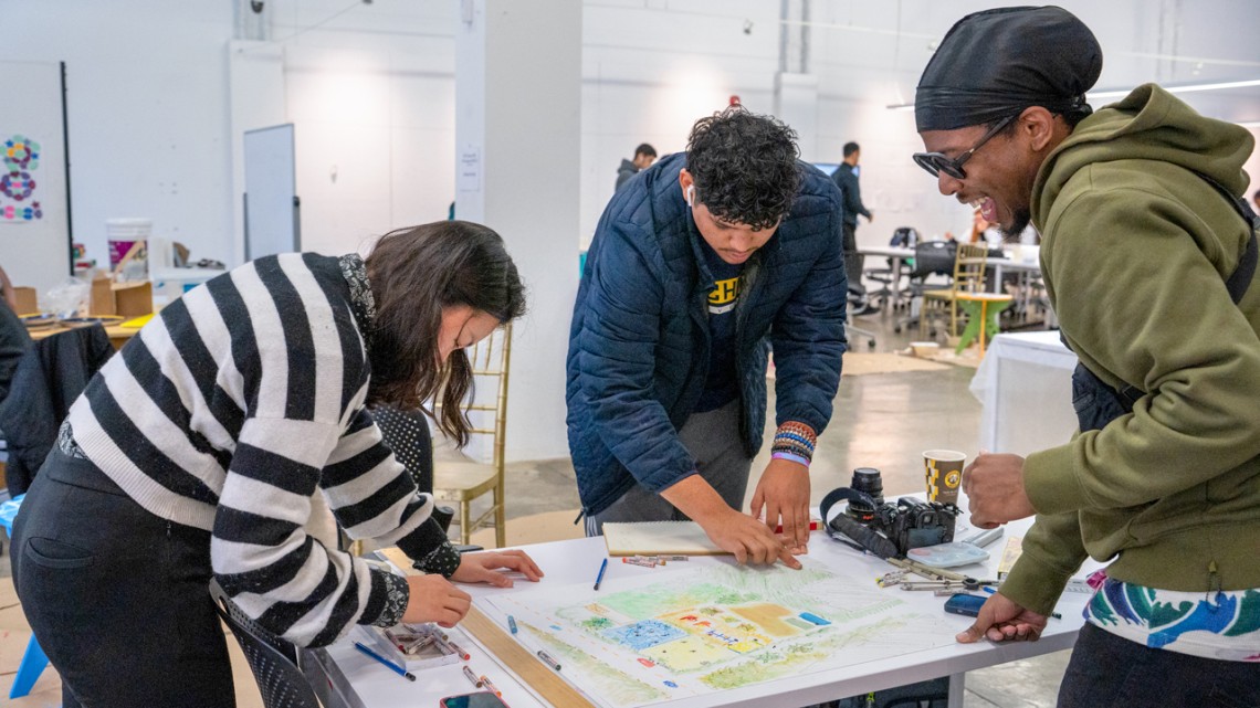 Cornell architecture students Jin Cho (left) and Cedric Lalanne (right) work with a Detroit high school student enrolled in the University of Michigan Architecture Preparation Program (ArcPrep) in the ArcPrep studio space.